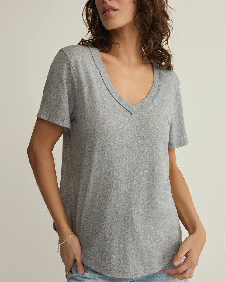 Woman wearing a gray V-neck t-shirt against a neutral background