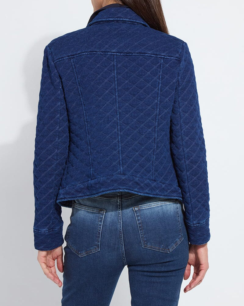 Person wearing a blue quilted jacket and jeans on a white background