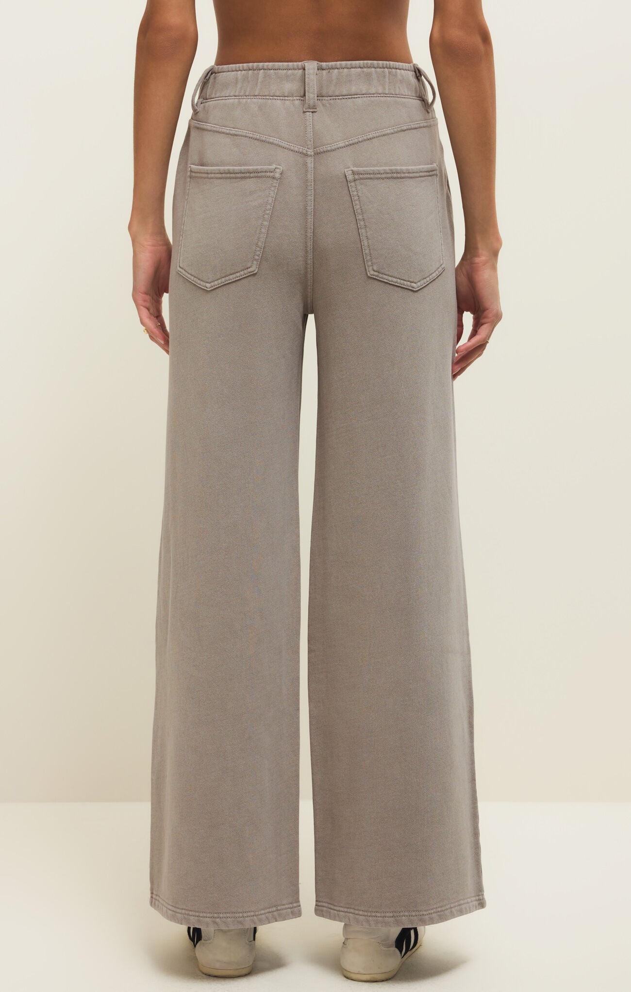 Beige wide-leg pants worn by a person on a plain background