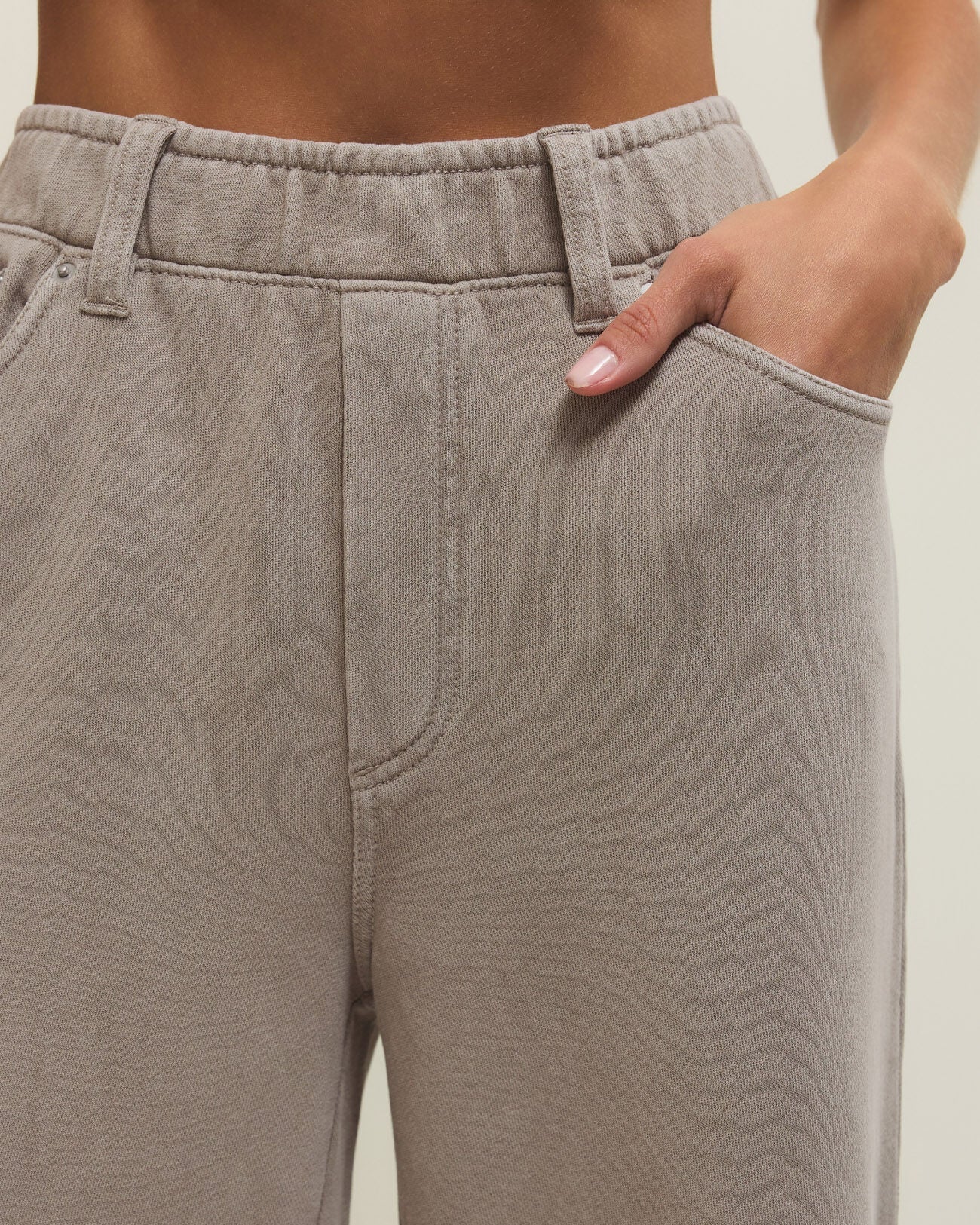 Close-up of beige pants with a neutral background