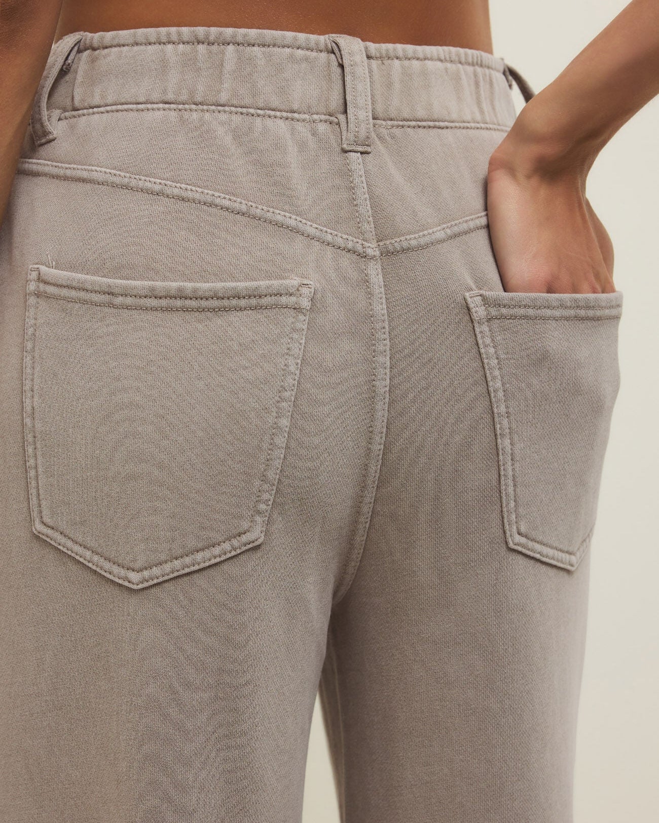 Close-up of gray pants with a neutral background