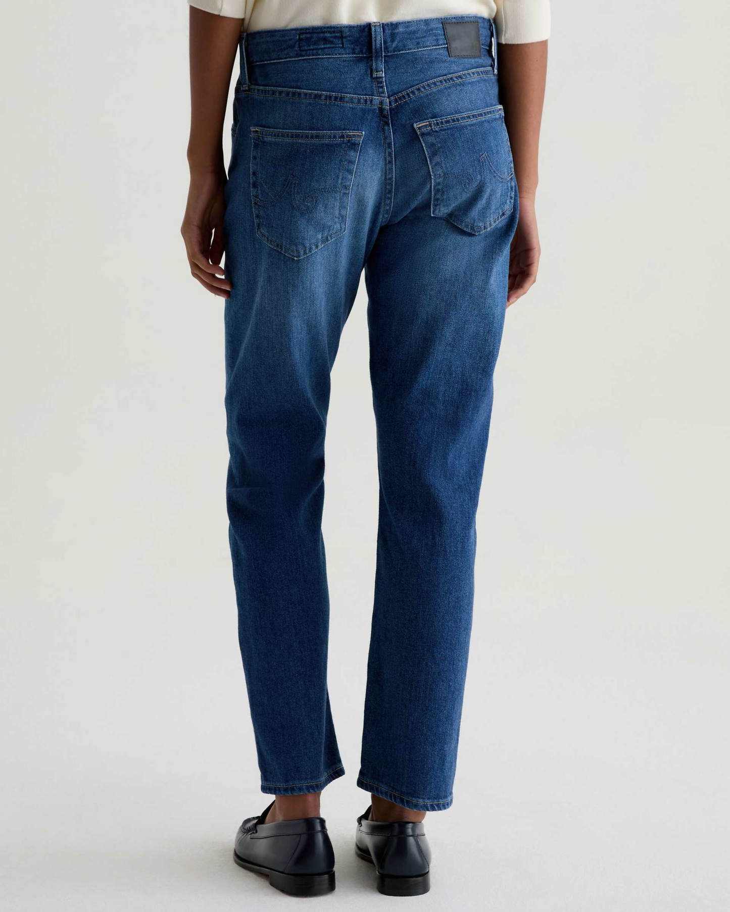 Person wearing blue jeans on a white background