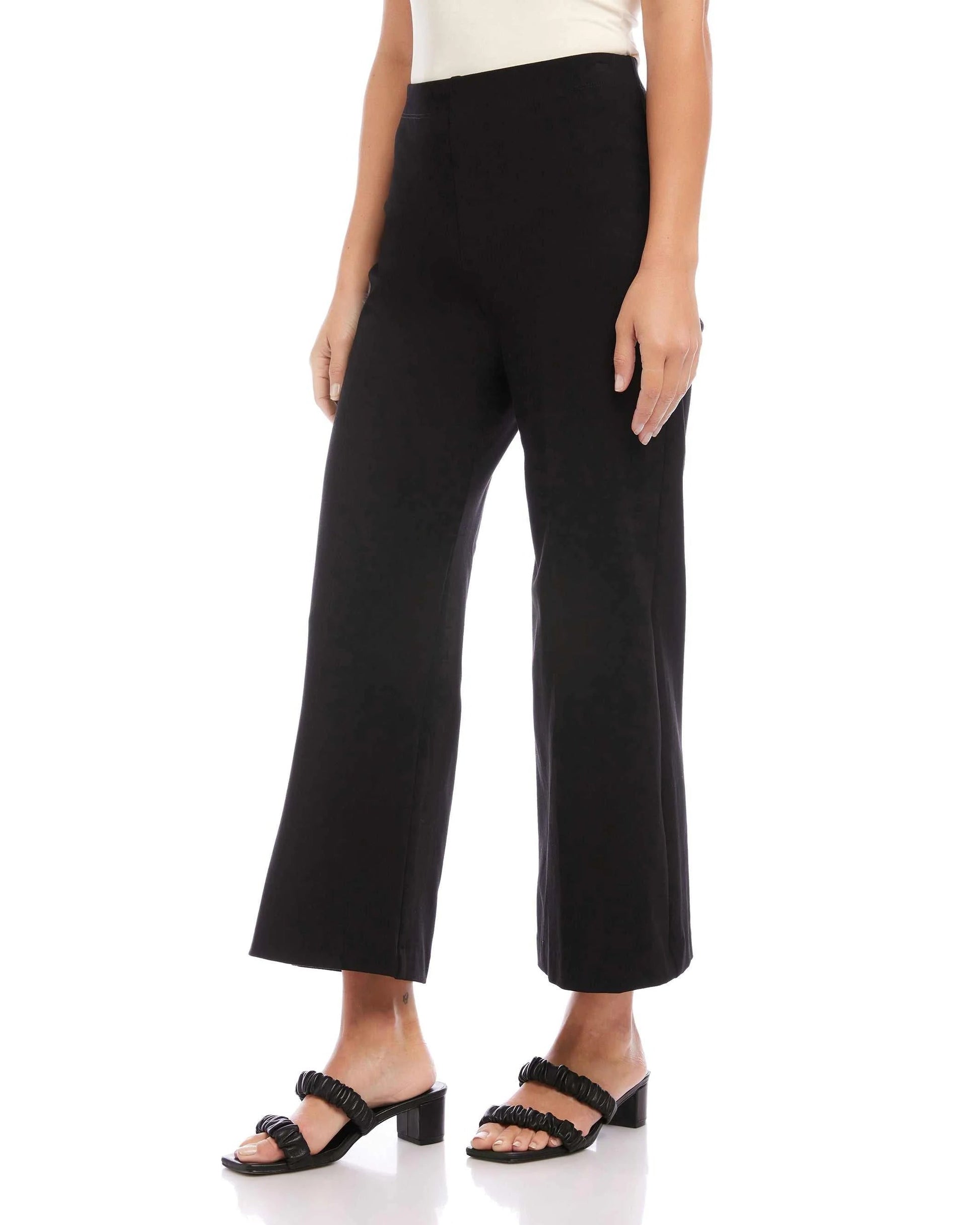 Side view of a model wearing the Fifteen Twenty Wide-leg Cropped pants in black in front of a white background