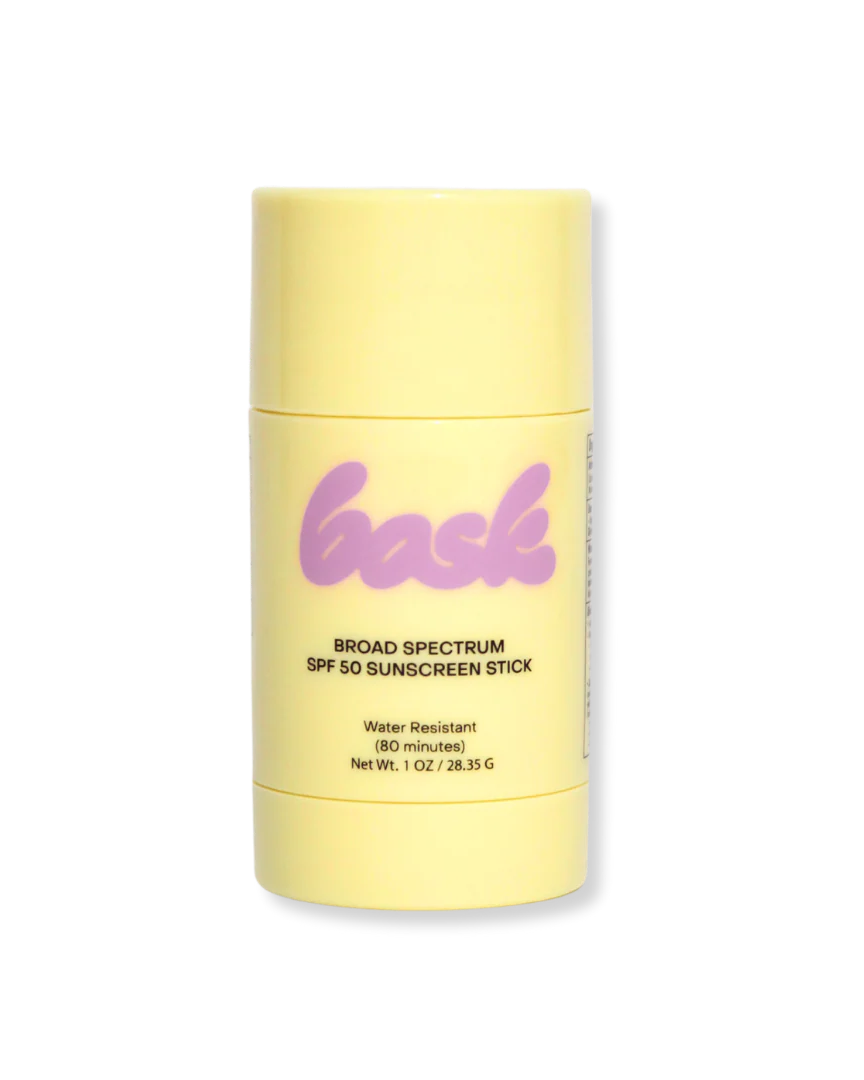 Yellow sunscreen stick with 'bask' branding on a white background