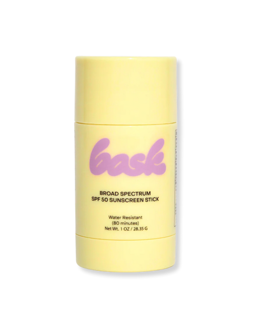 Yellow sunscreen stick with 'bask' branding on a white background