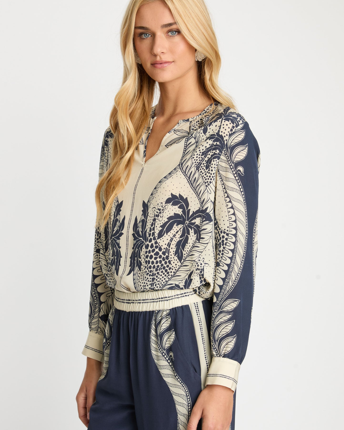 Woman wearing a navy and beige patterned outfit on a white background