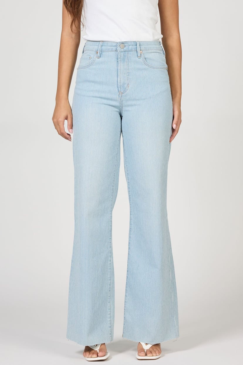 Light blue flared jeans worn by a person on a white background