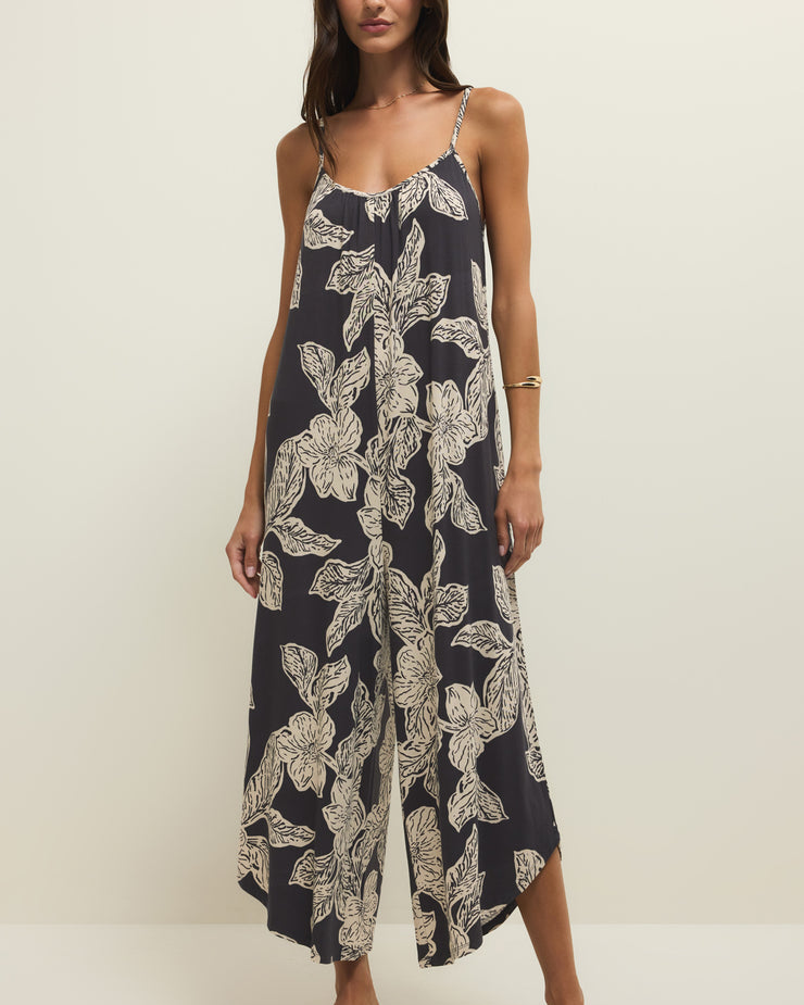 Woman wearing a navy floral jumpsuit on a white background