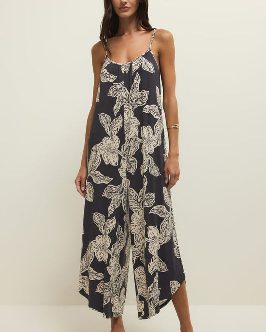 Woman wearing a navy floral jumpsuit on a white background