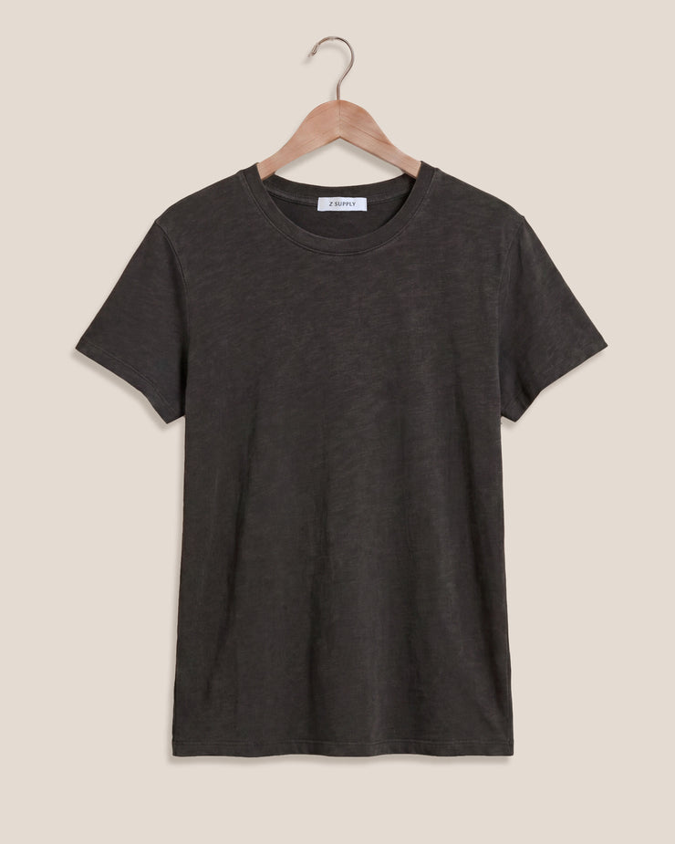 Black t-shirt on a hanger against a beige background