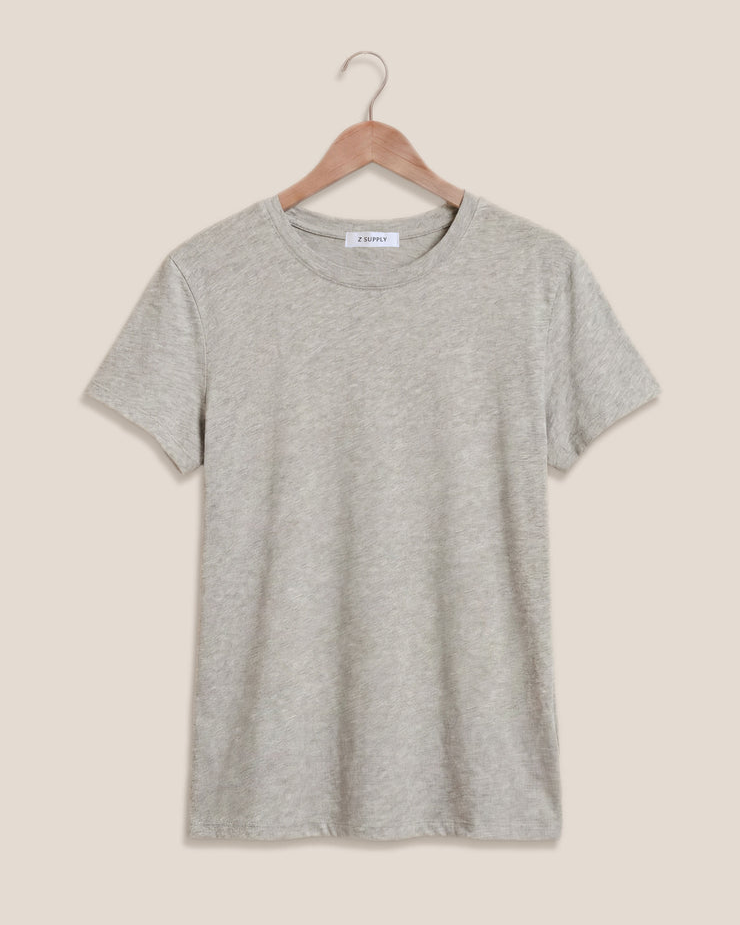 Gray t-shirt on a wooden hanger against a beige background