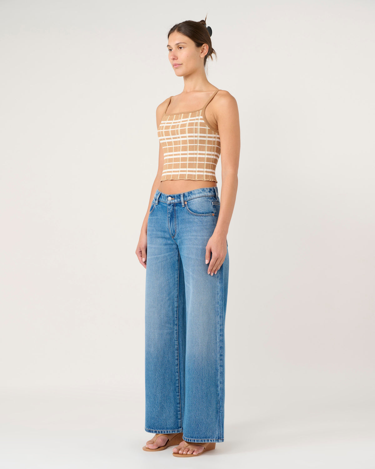 Woman wearing a striped top and blue jeans on a white background