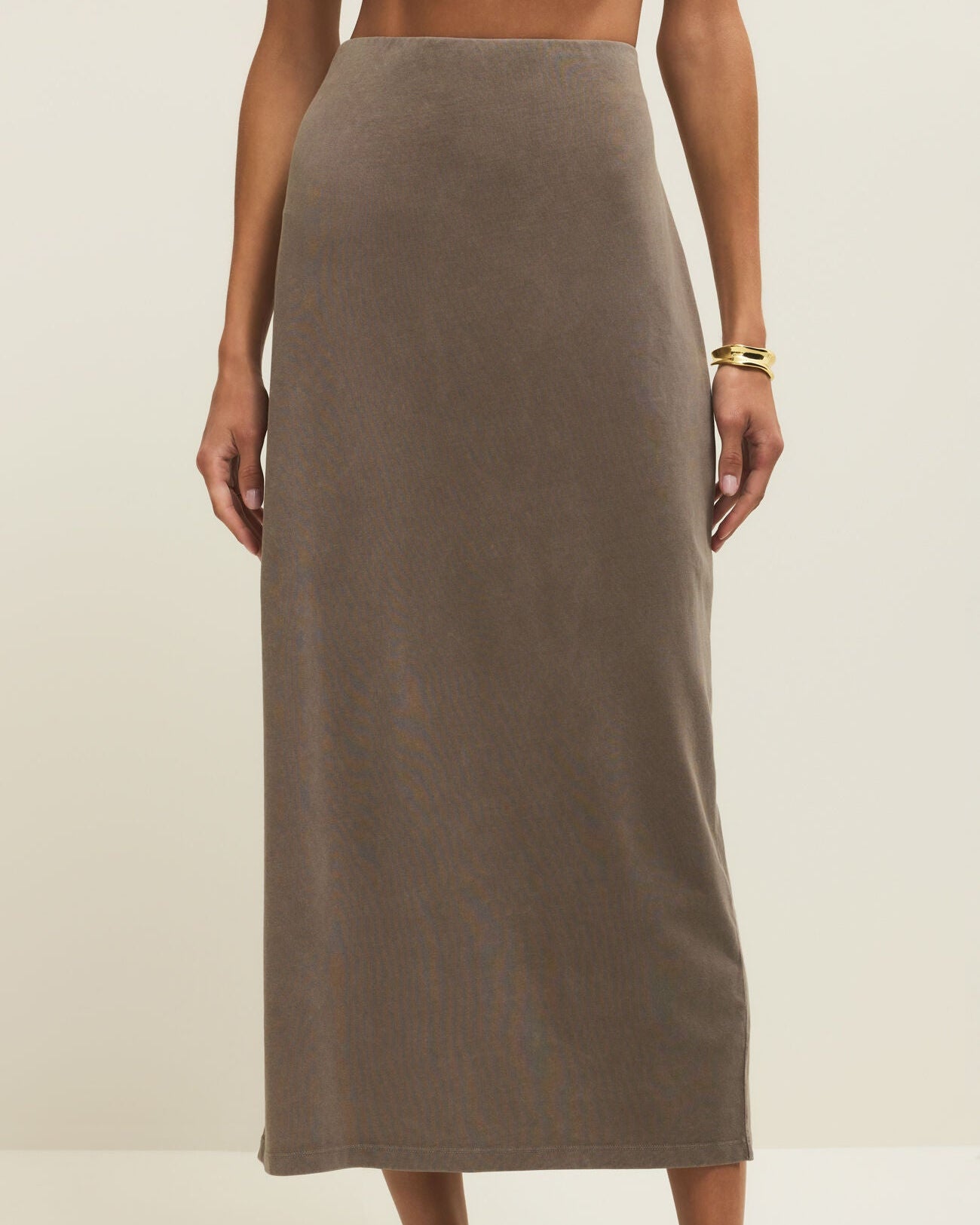 Person wearing a brown skirt on a plain background