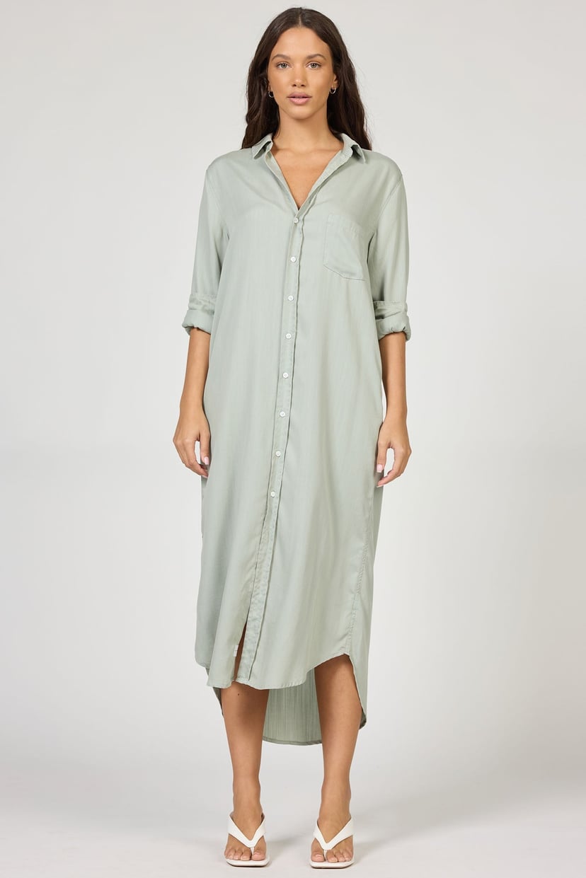 Woman wearing a light green button-up dress on a white background