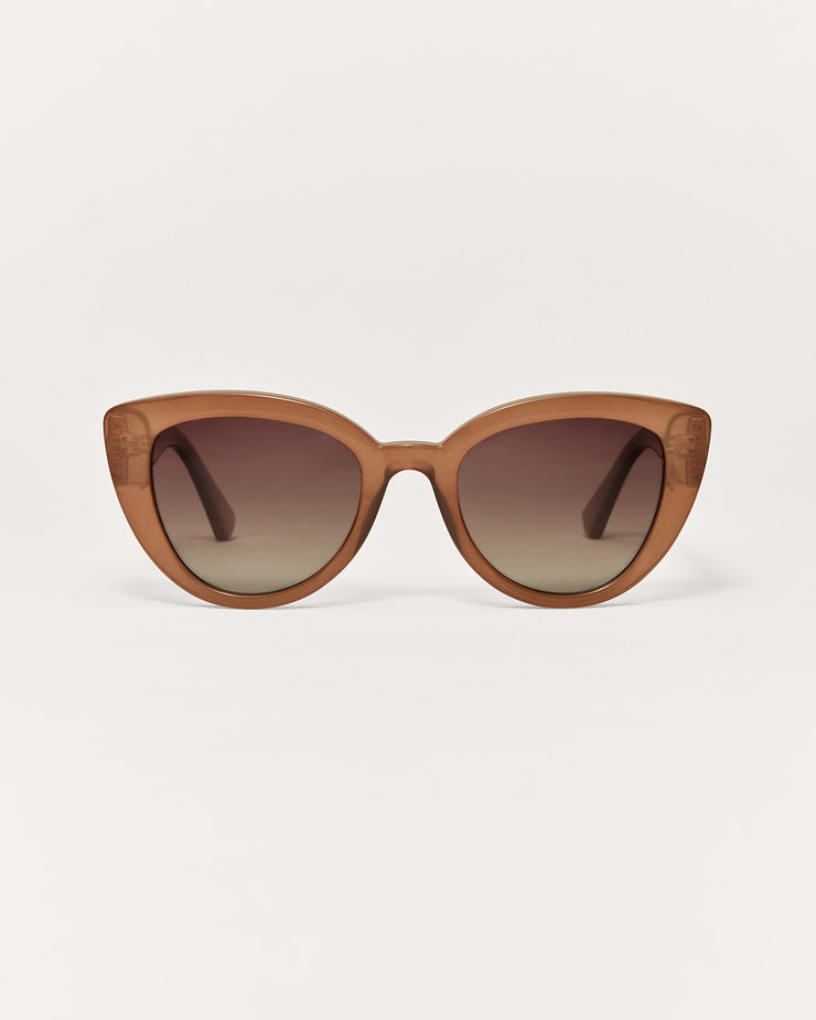 Brown cat-eye sunglasses on a light beige background