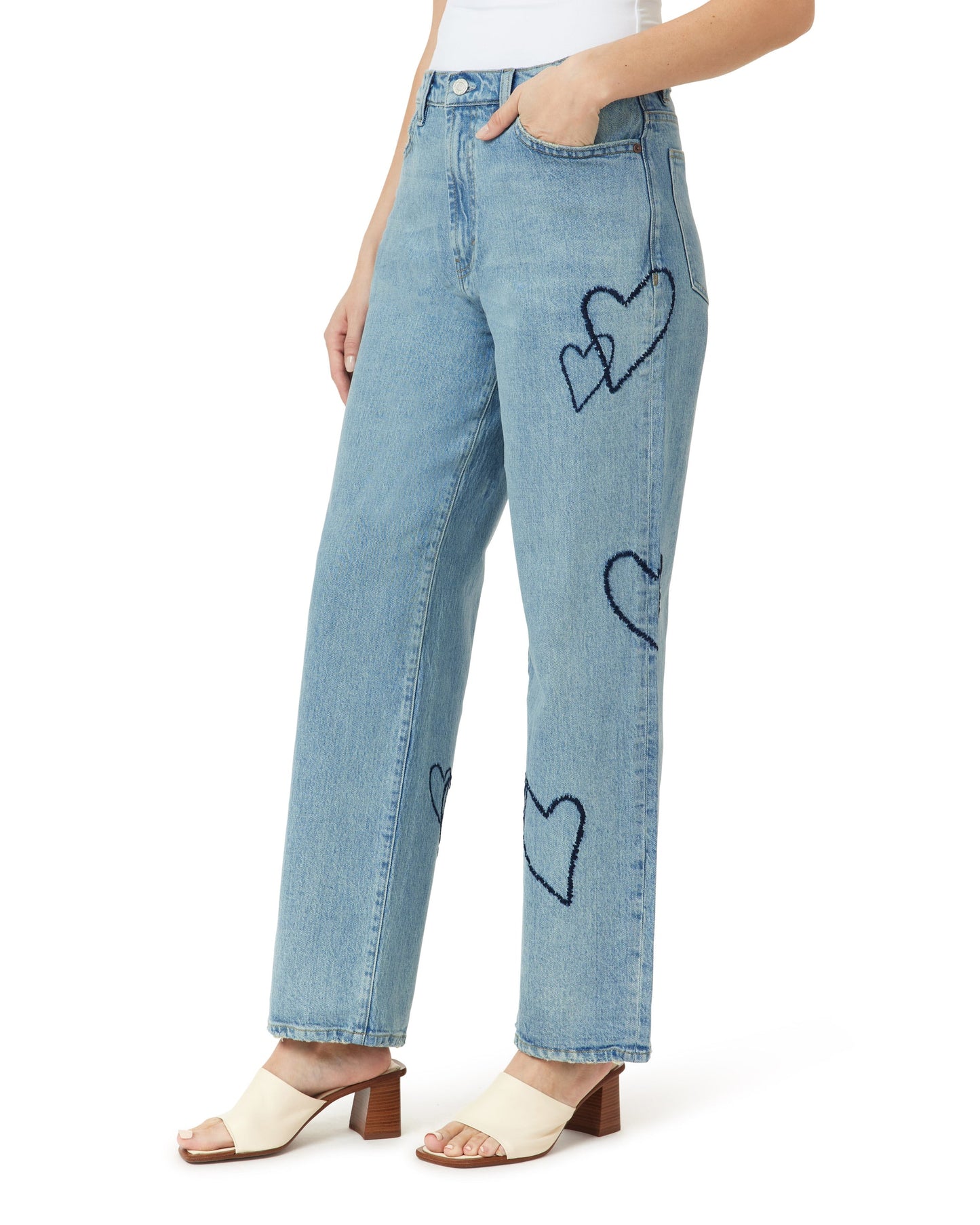 Light blue jeans with heart designs worn by a person on a white background