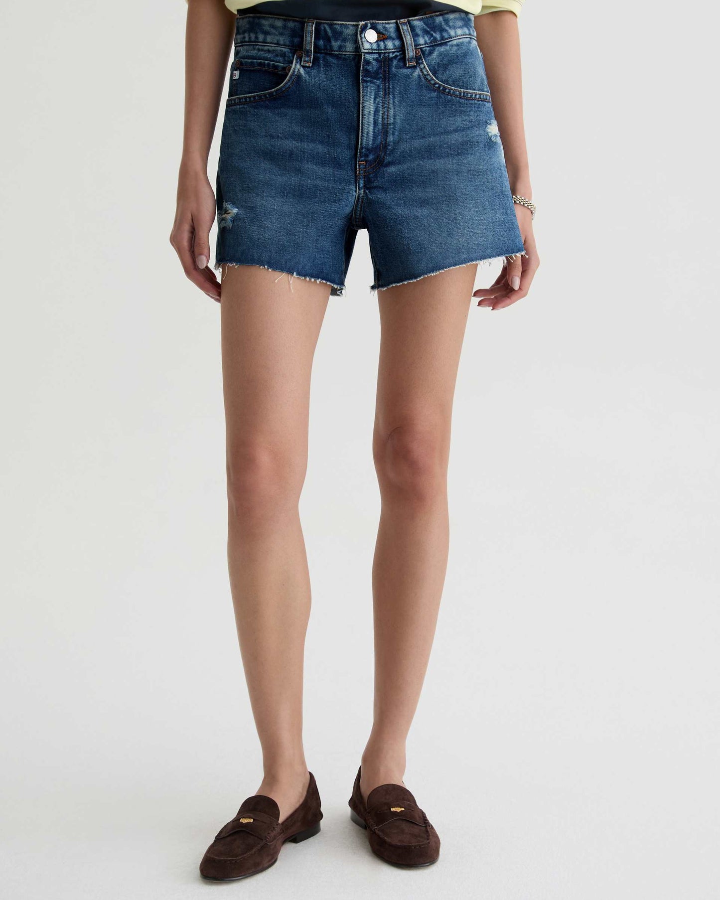 Person wearing blue denim shorts on a white background
