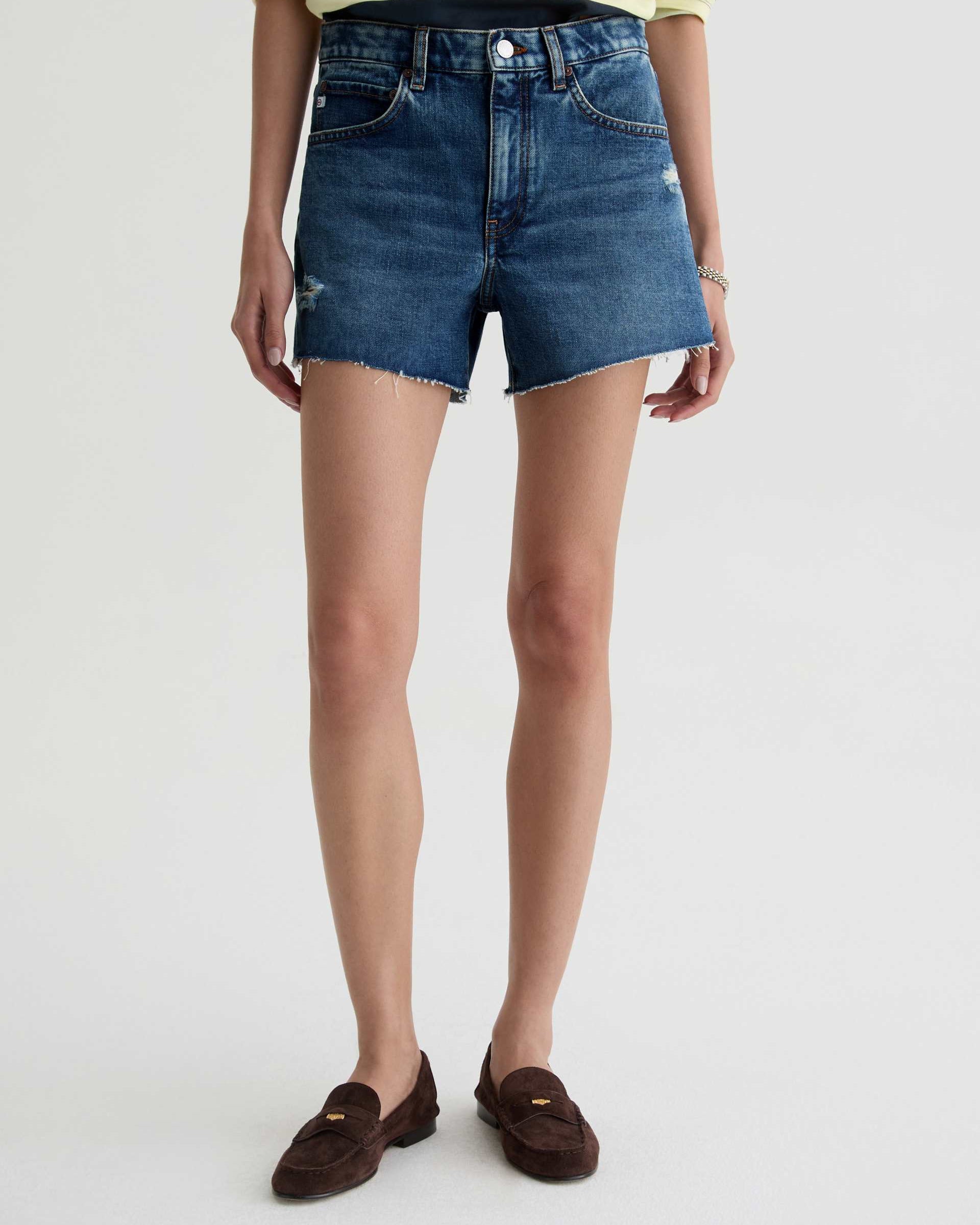 Person wearing blue denim shorts on a white background