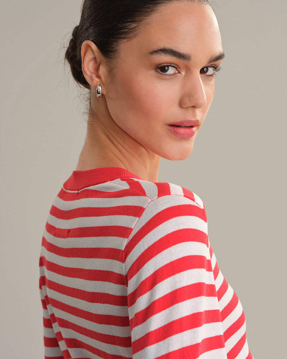 Woman wearing a red and white striped shirt against a plain background