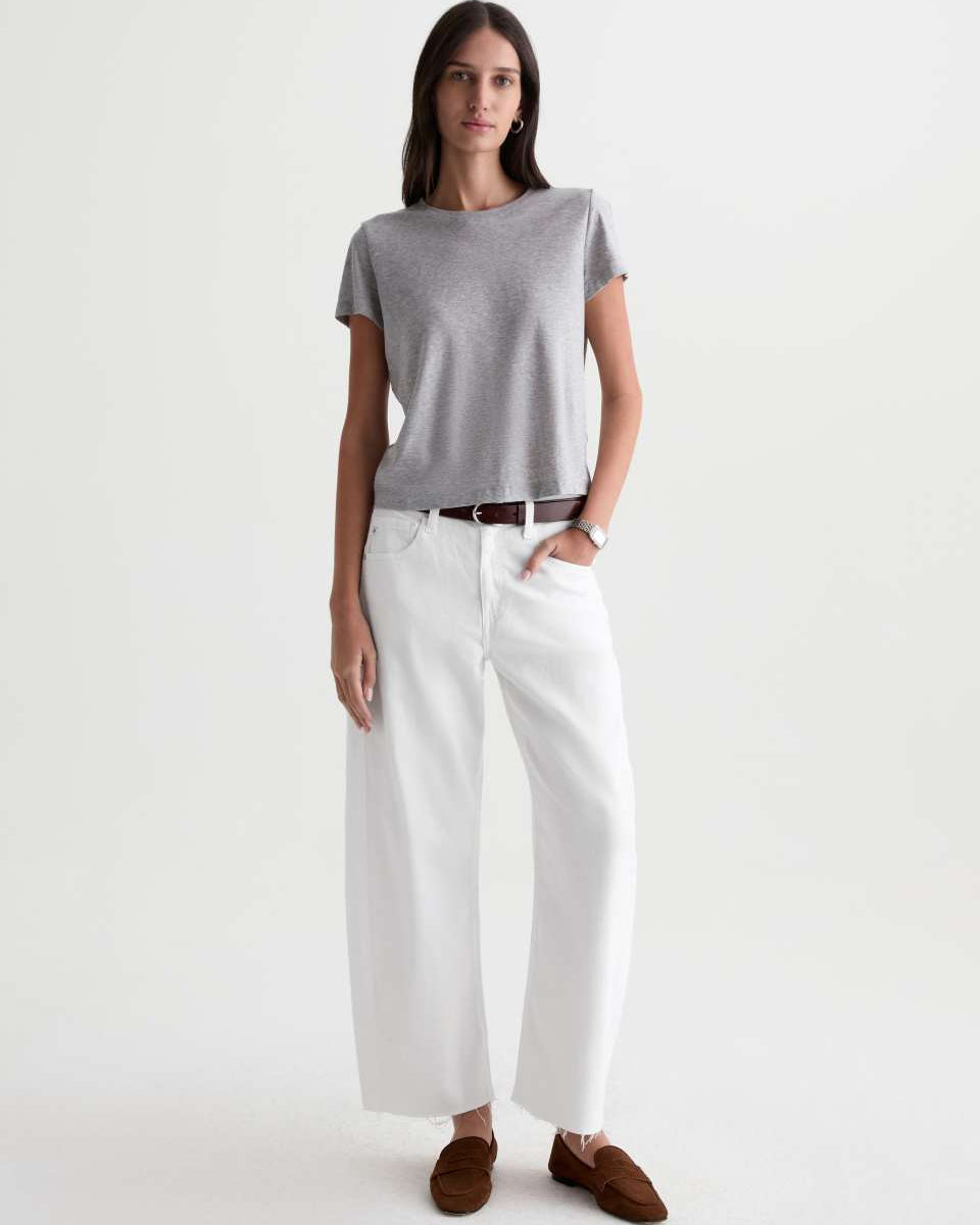 Woman wearing a gray t-shirt and white pants on a white background
