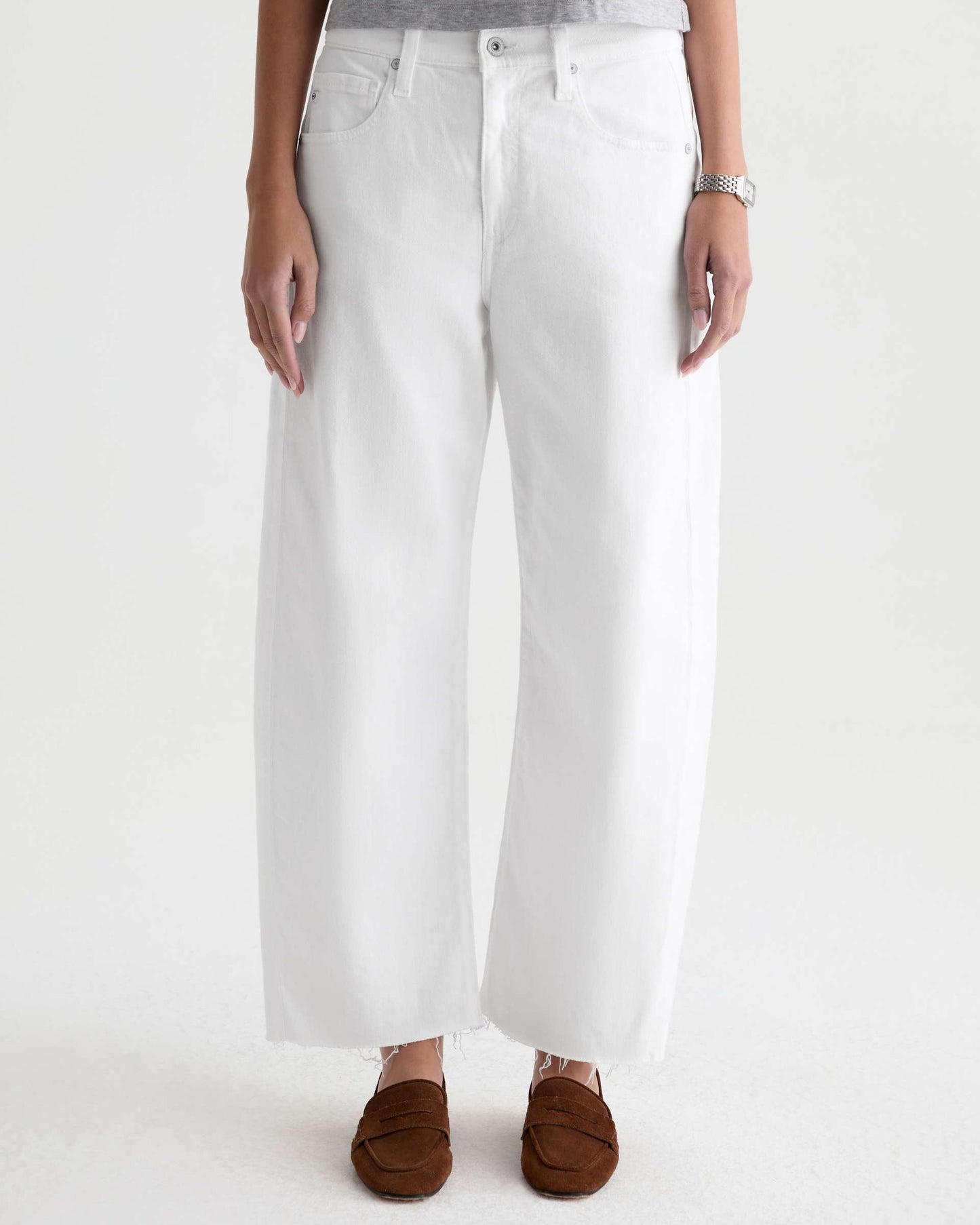 Person wearing white wide-leg jeans on a plain background