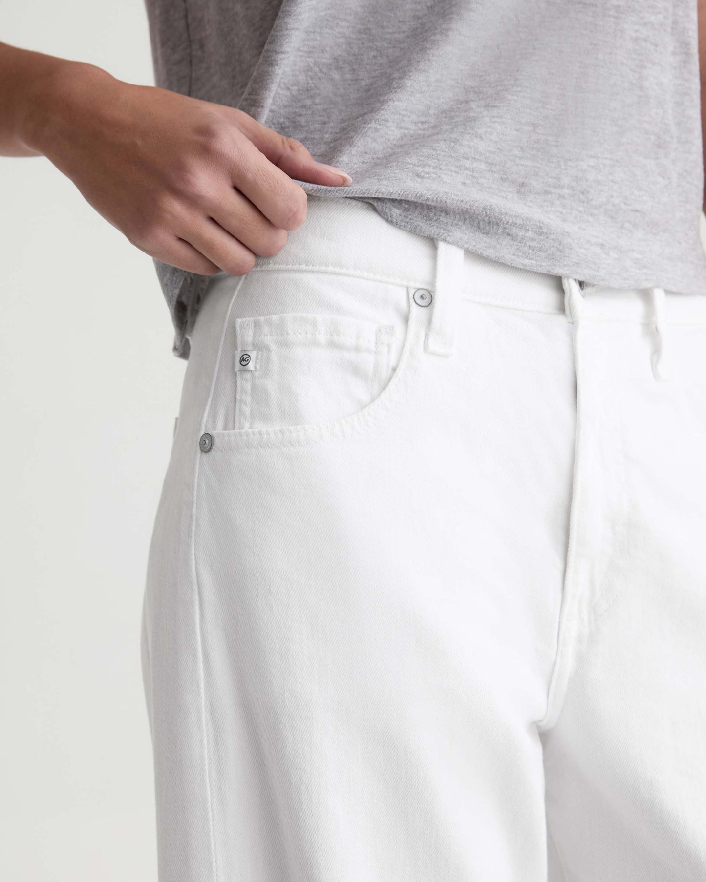 Person wearing white pants with a plain background