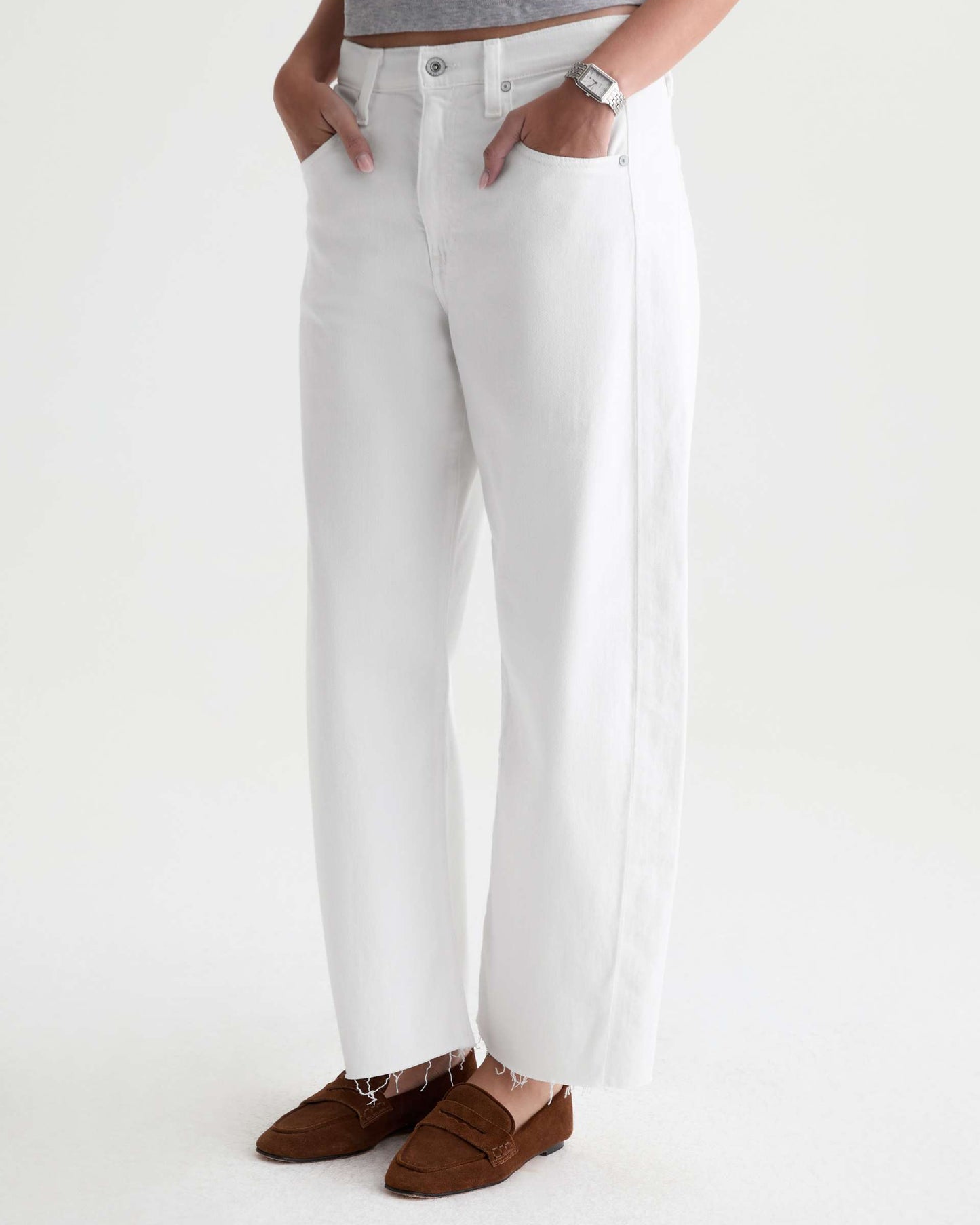Person wearing white pants with a plain background