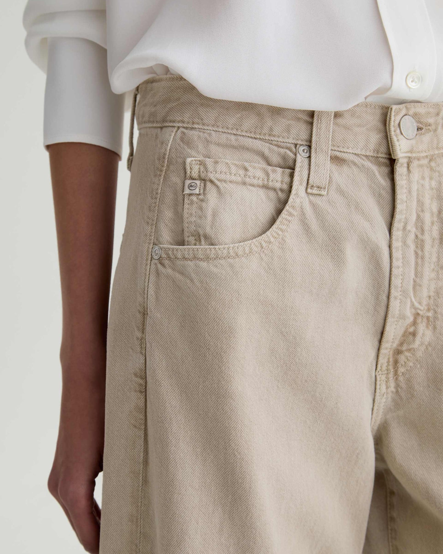 Beige pants worn by a person on a plain background