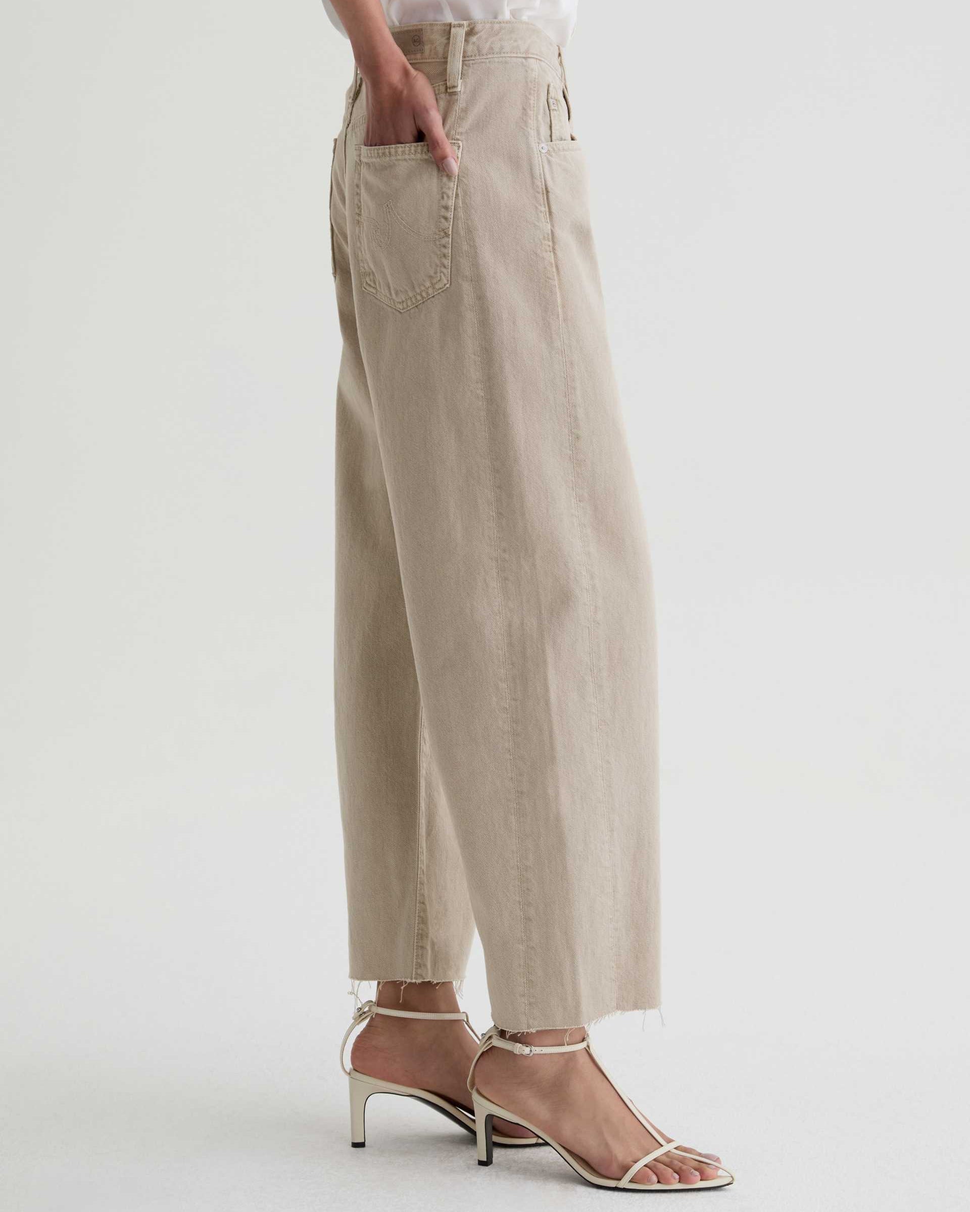 Beige pants worn by a person on a white background