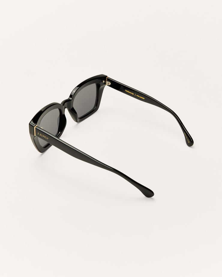 Black sunglasses with gold accents on a white background