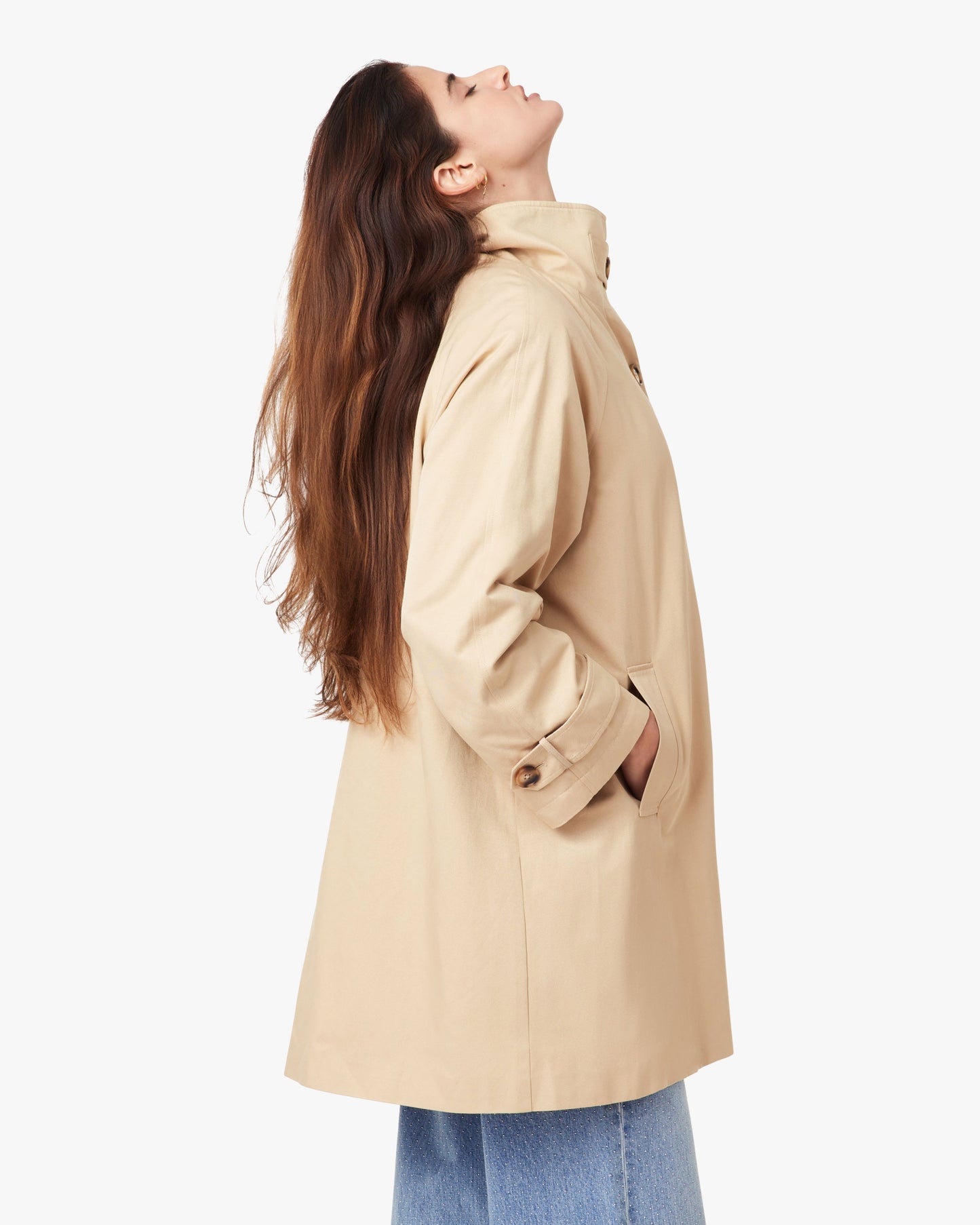Woman wearing a beige coat on a white background