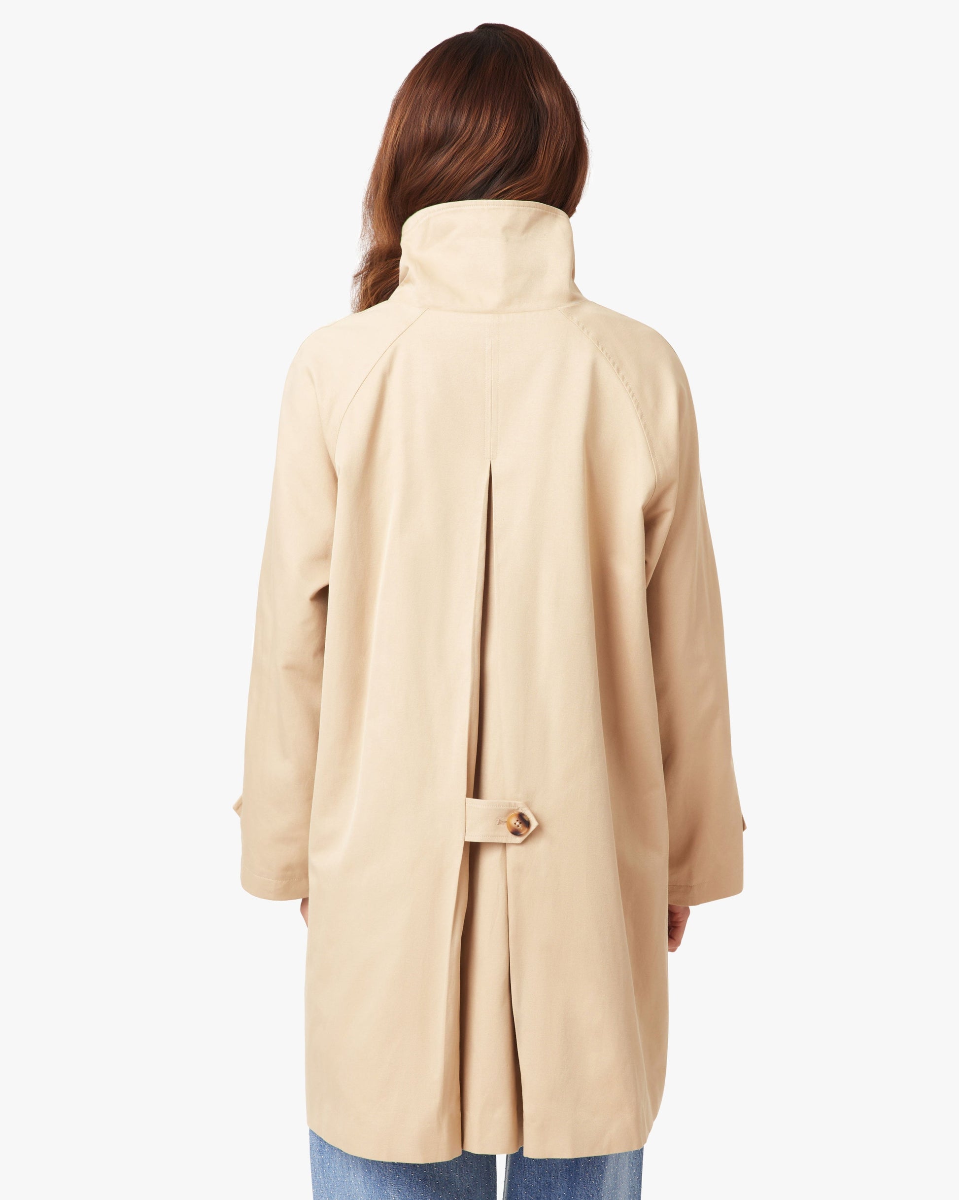 Beige coat worn by a person on a white background
