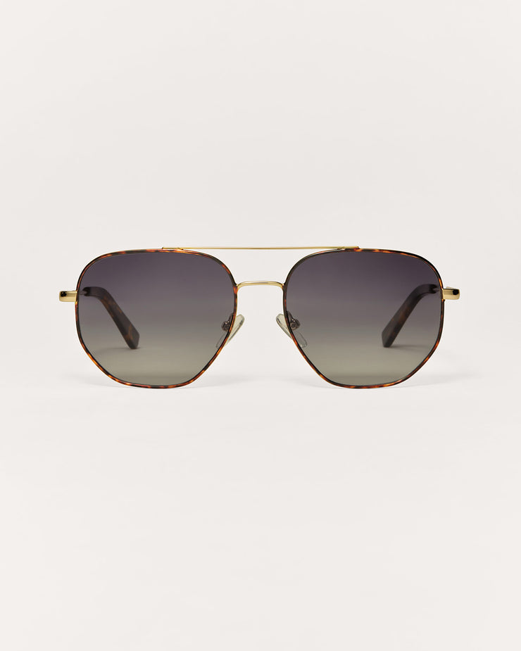 Aviator sunglasses with gold frame and dark lenses on a light gray background