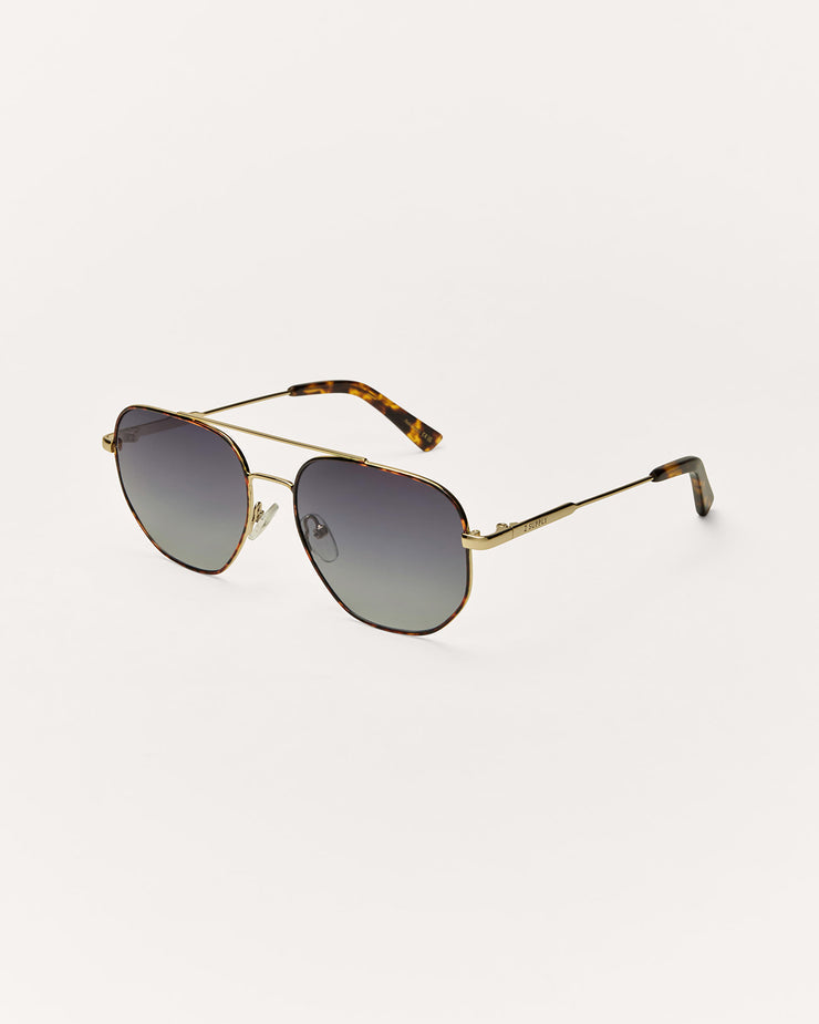 Sunglasses with gold frame and tortoiseshell accents on a white background