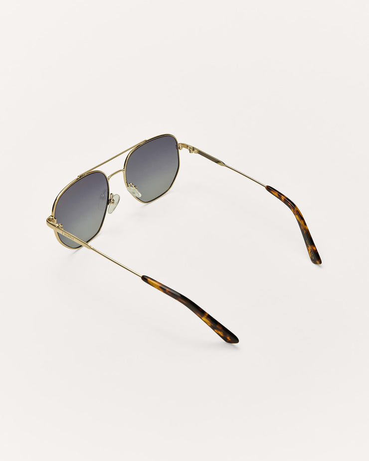 Sunglasses with gold frame and tortoiseshell arms on a white background
