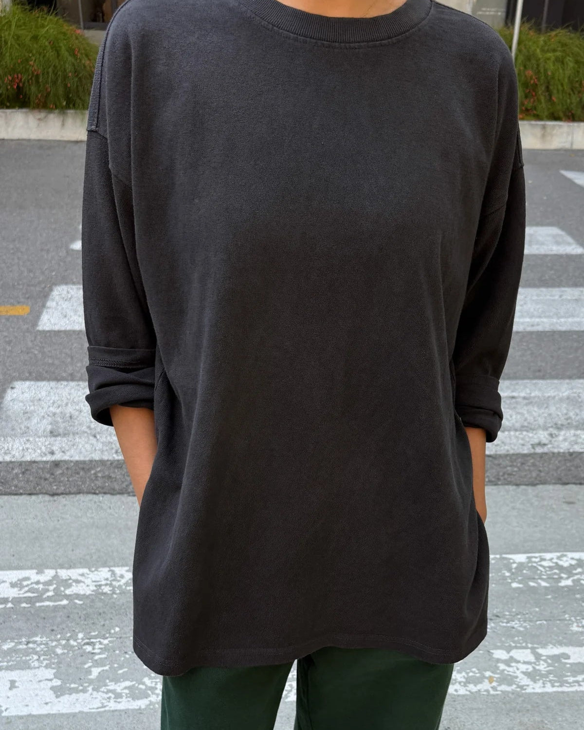 Person wearing a black oversized sweatshirt on a street