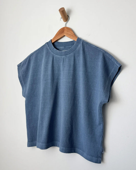 Blue sleeveless shirt on a wooden hanger against a white background