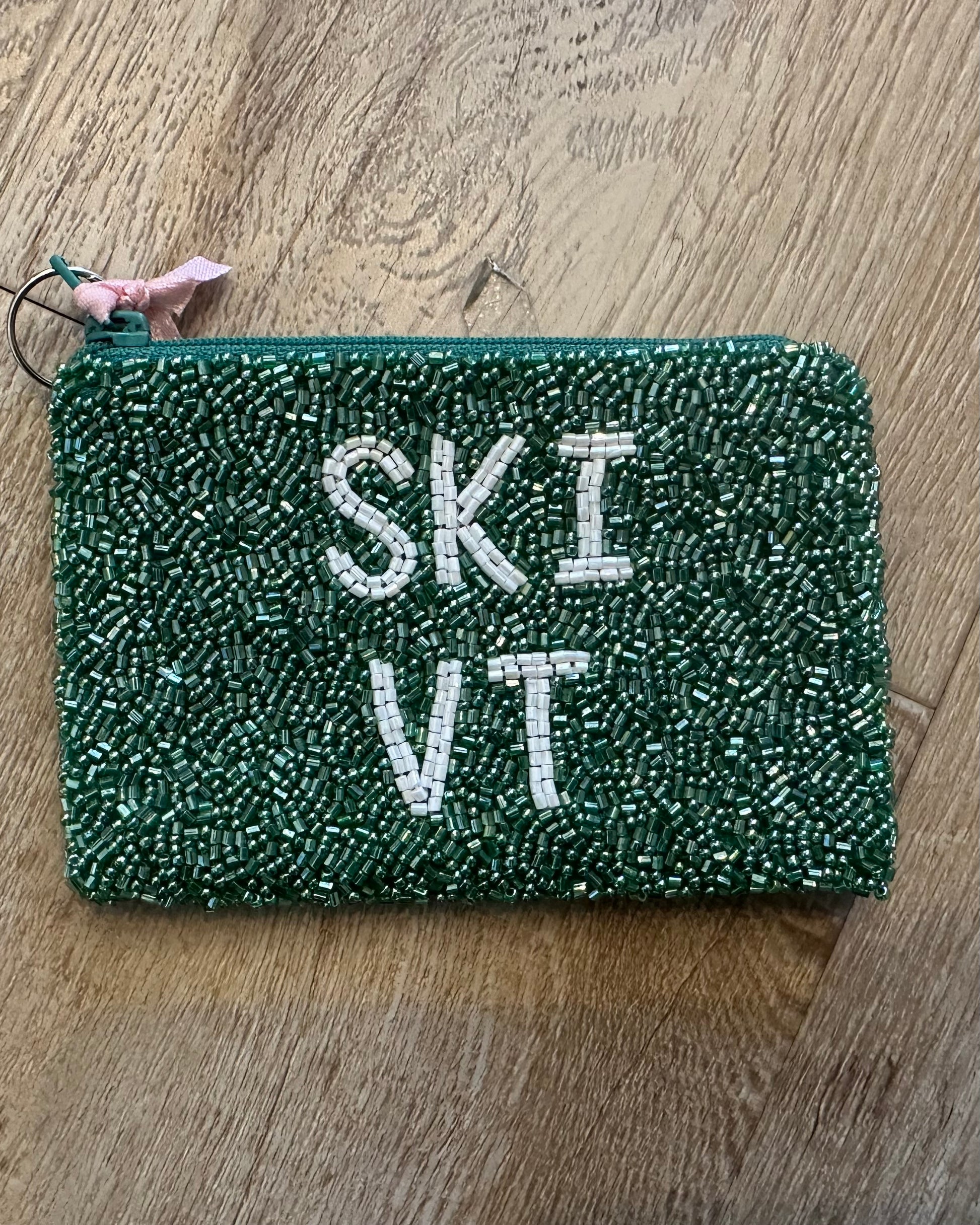 Image of ski Vermont in green and white on a wood background
