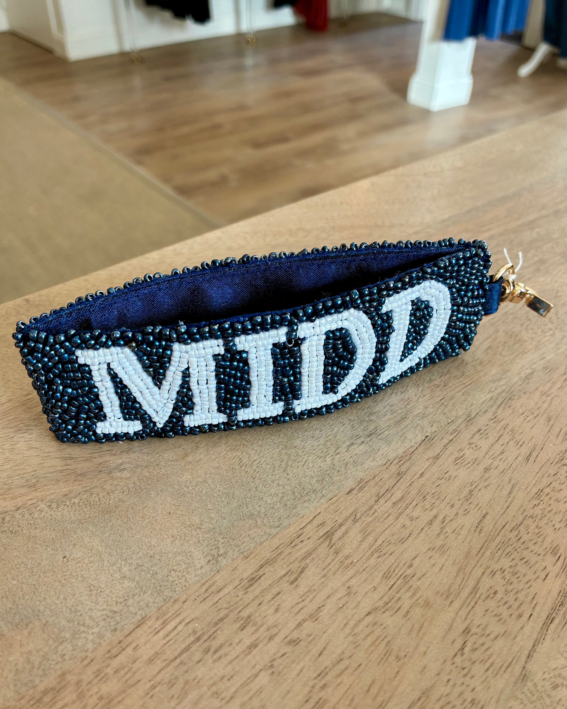 Beaded key chain with 'MIDD' text on a wooden surface