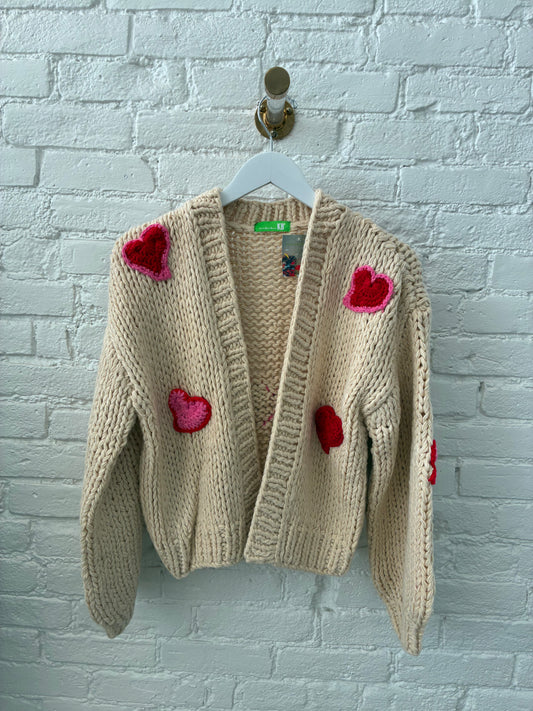 beige knit cardigan with pink and red knit hearts on white, brich background