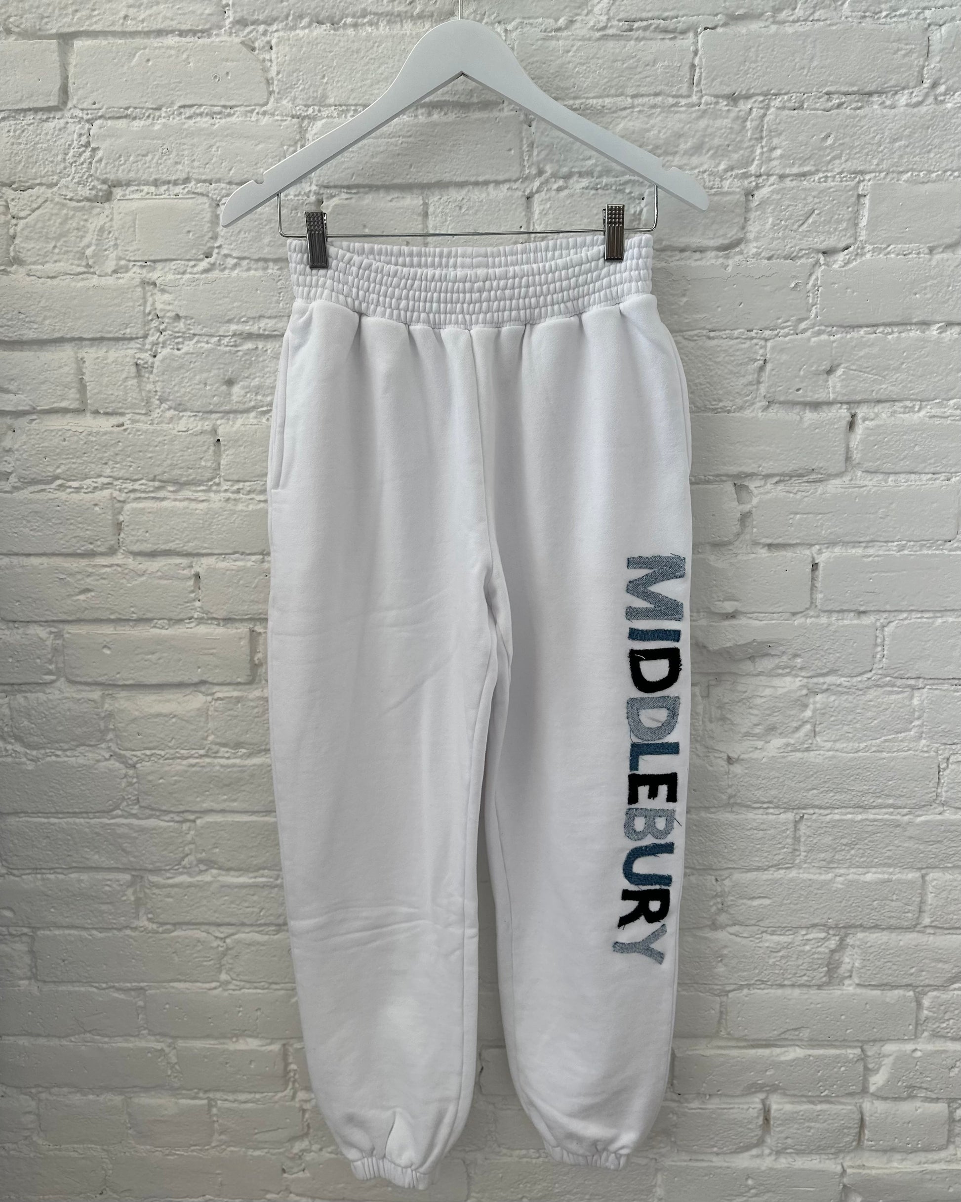 Image Of Middlebury Vermont Denim Letter Sweatpants On A White Brick Background