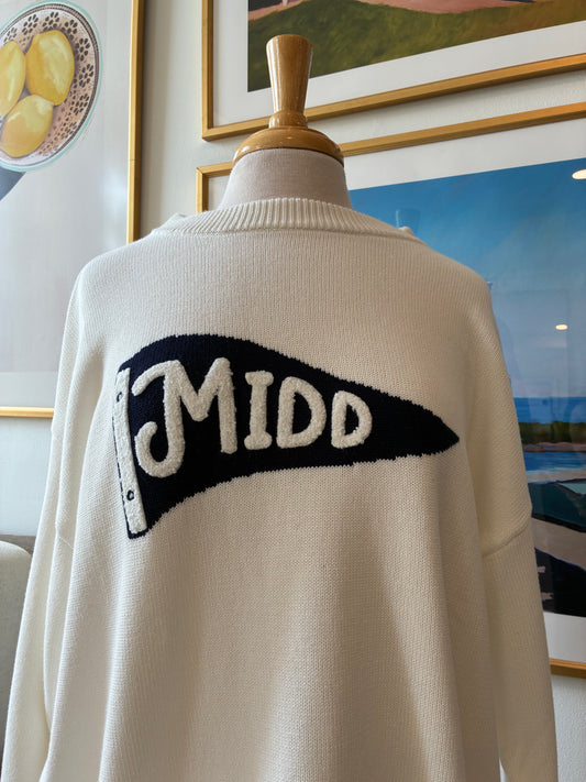 An off-white knit sweater displayed on a mannequin torso, featuring a large black pennant-shaped graphic with the word 'MIDD' in white lettering across the chest.