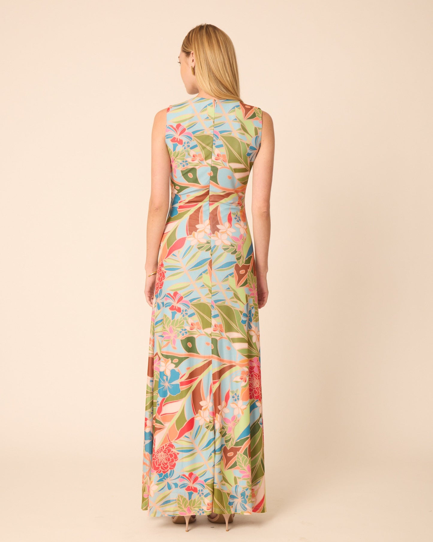 Woman wearing a colorful floral dress on a beige background