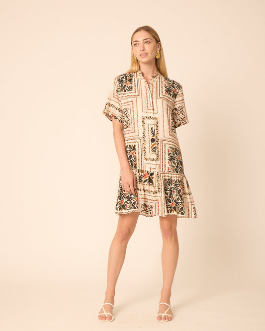 Woman wearing a patterned dress on a beige background