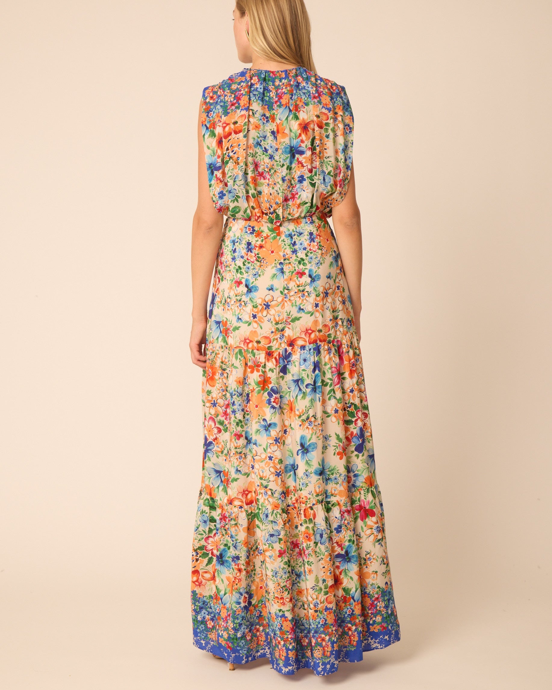 Woman wearing a colorful floral dress on a beige background