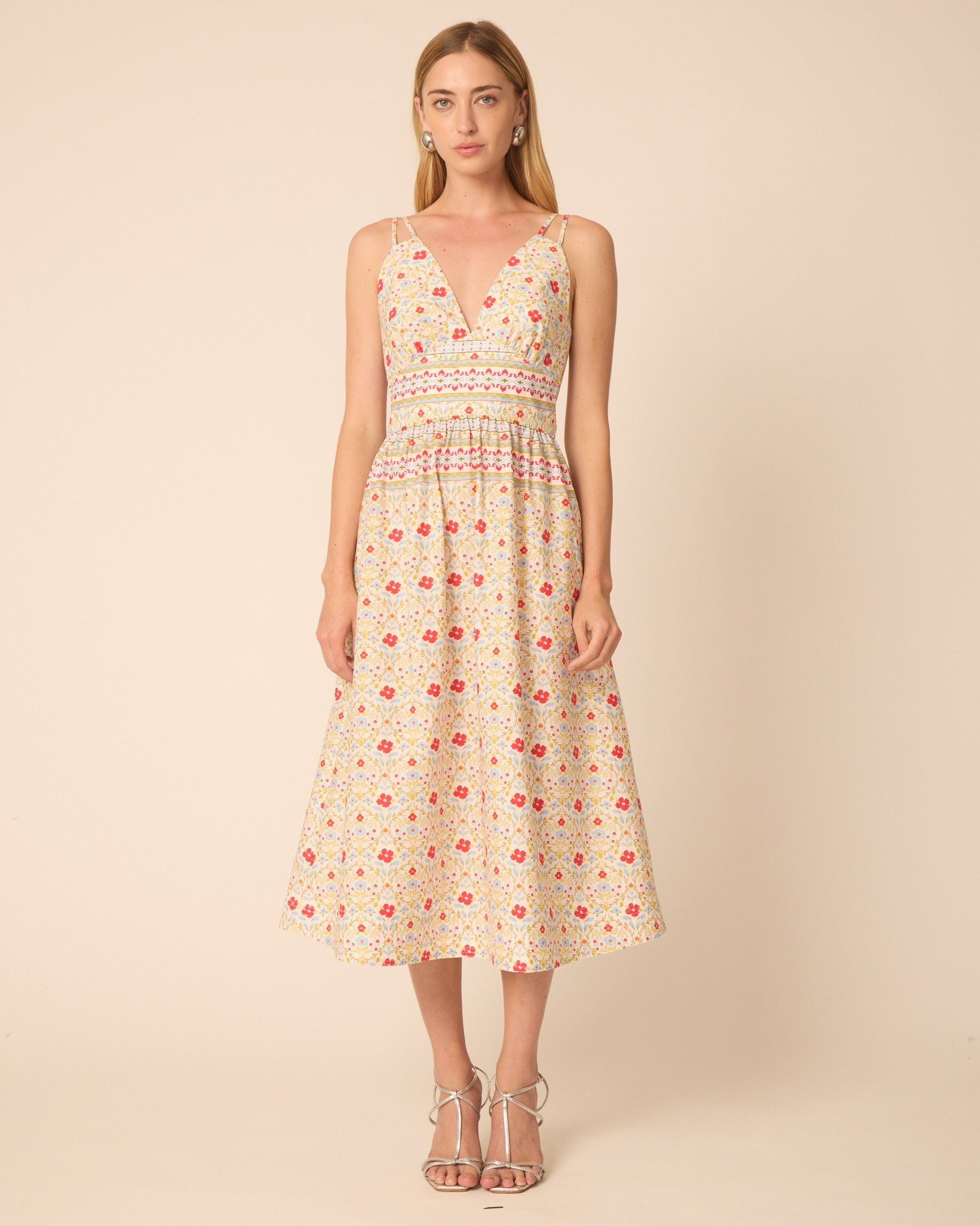 Woman wearing a floral dress against a beige background