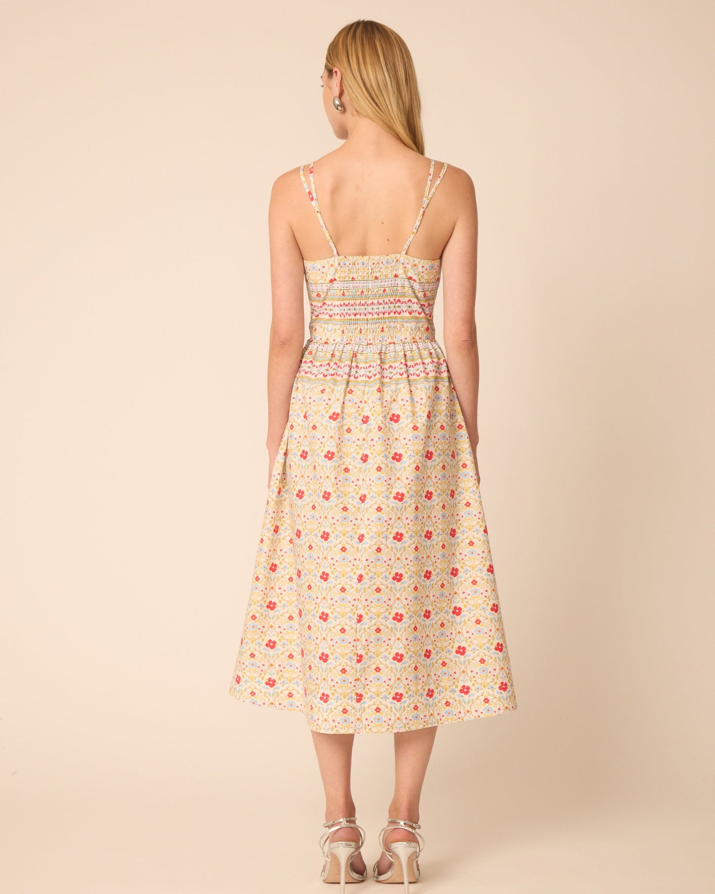 Woman wearing a floral dress on a beige background