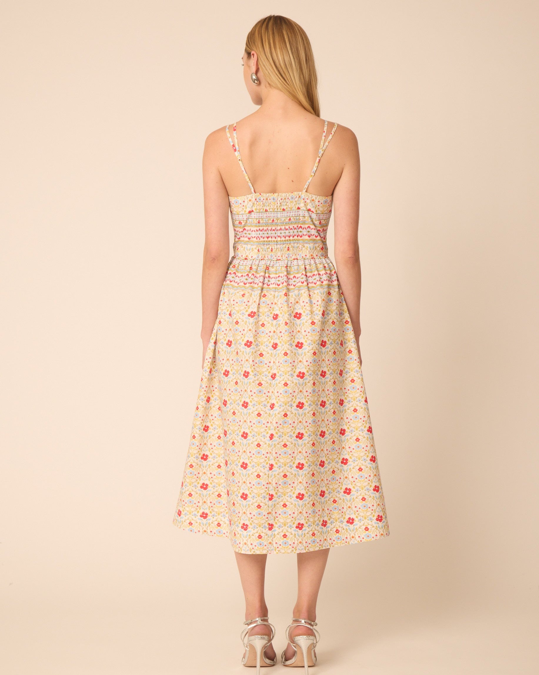 Woman wearing a floral dress on a beige background