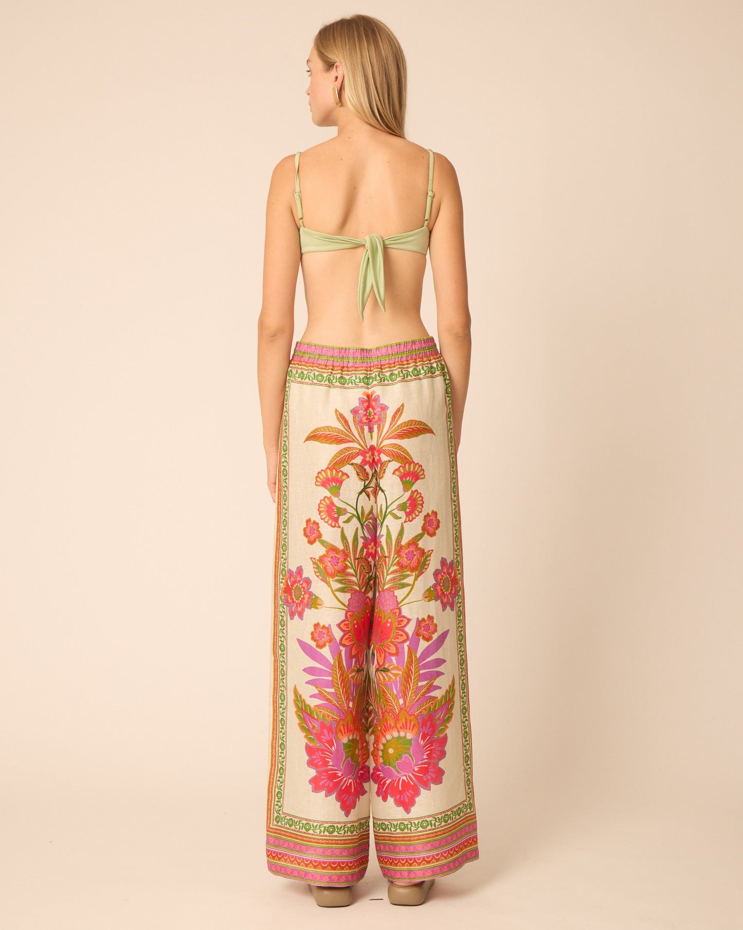 Woman wearing a floral dress with a beige background