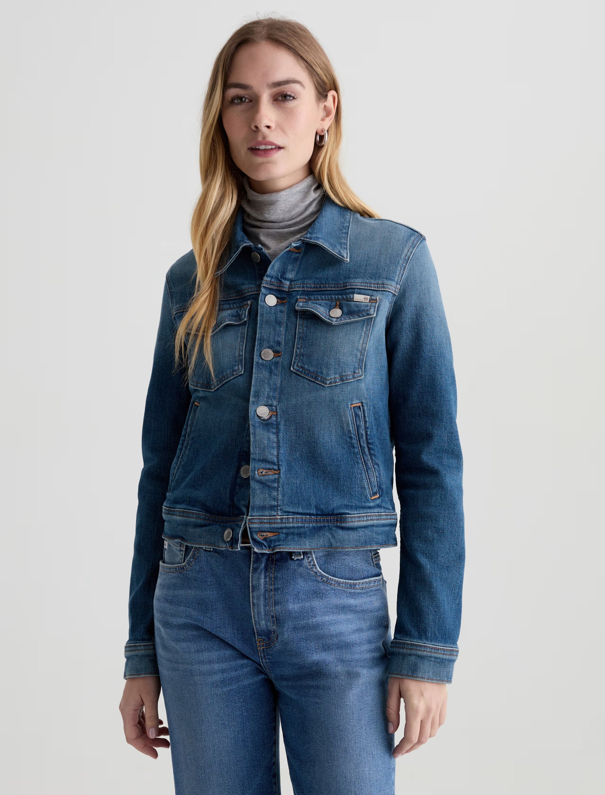 Model wearing AG denim jacket in front of a white background